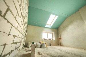 Interior of an apartment room with bare walls and ceiling under construction